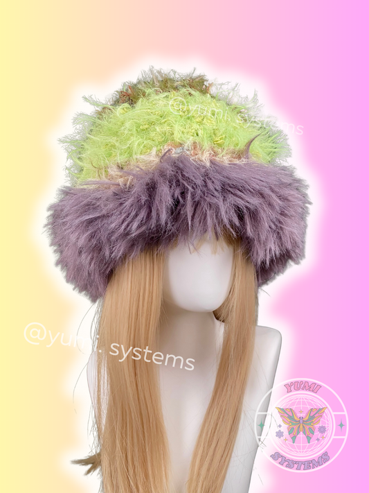 Close-up of a handmade shaggy plush hat in forest green and cyber pink with detachable ears, artisan crochet by yumi.systems.