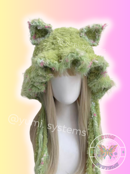 Close-up of a thick, colorful handmade animal ear hat with long tassels on a mannequin.