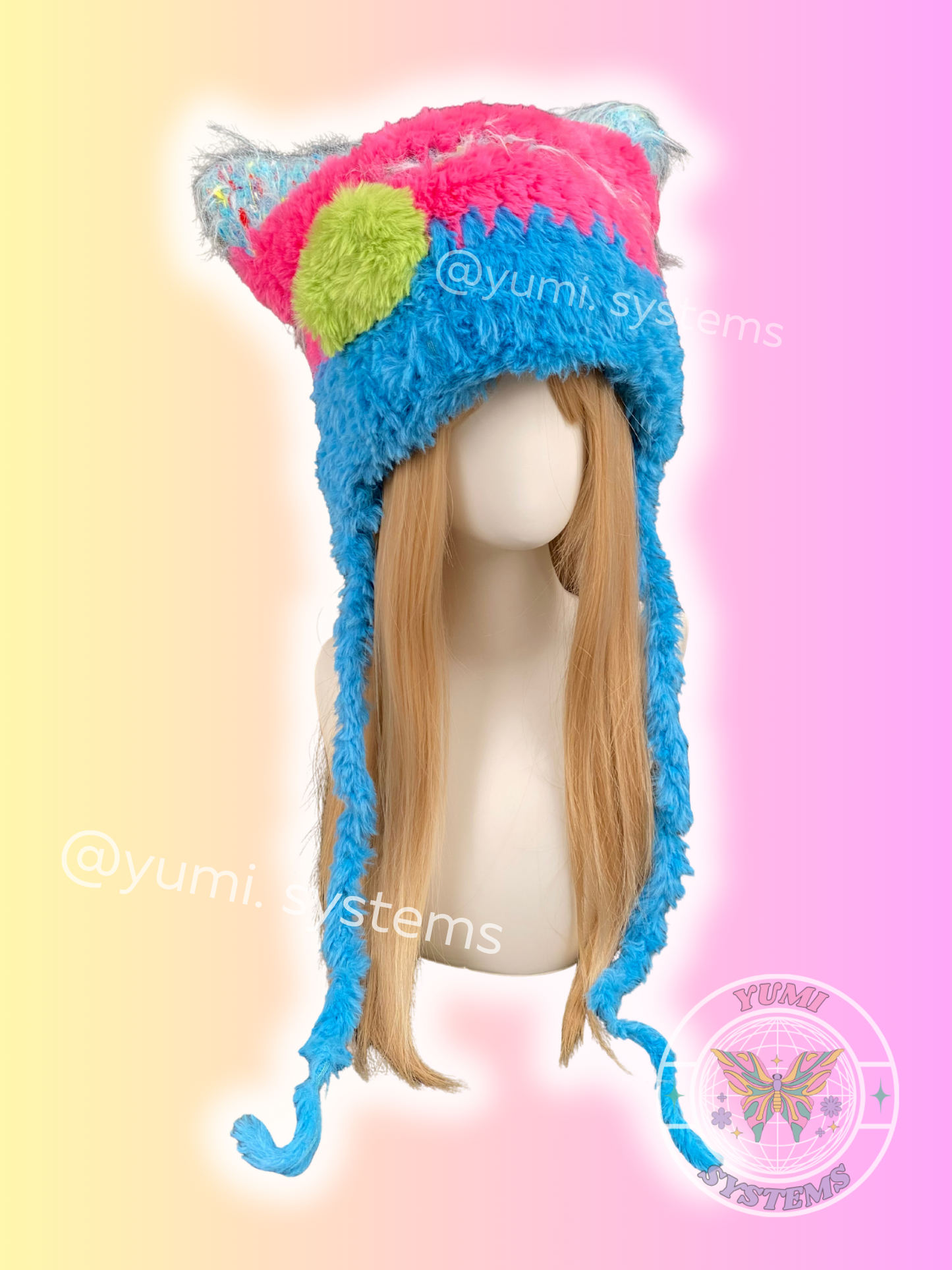 Close-up of a handmade shaggy plush hat with animal ears, multi-color neon and earth tone crochet by yumi.systems.