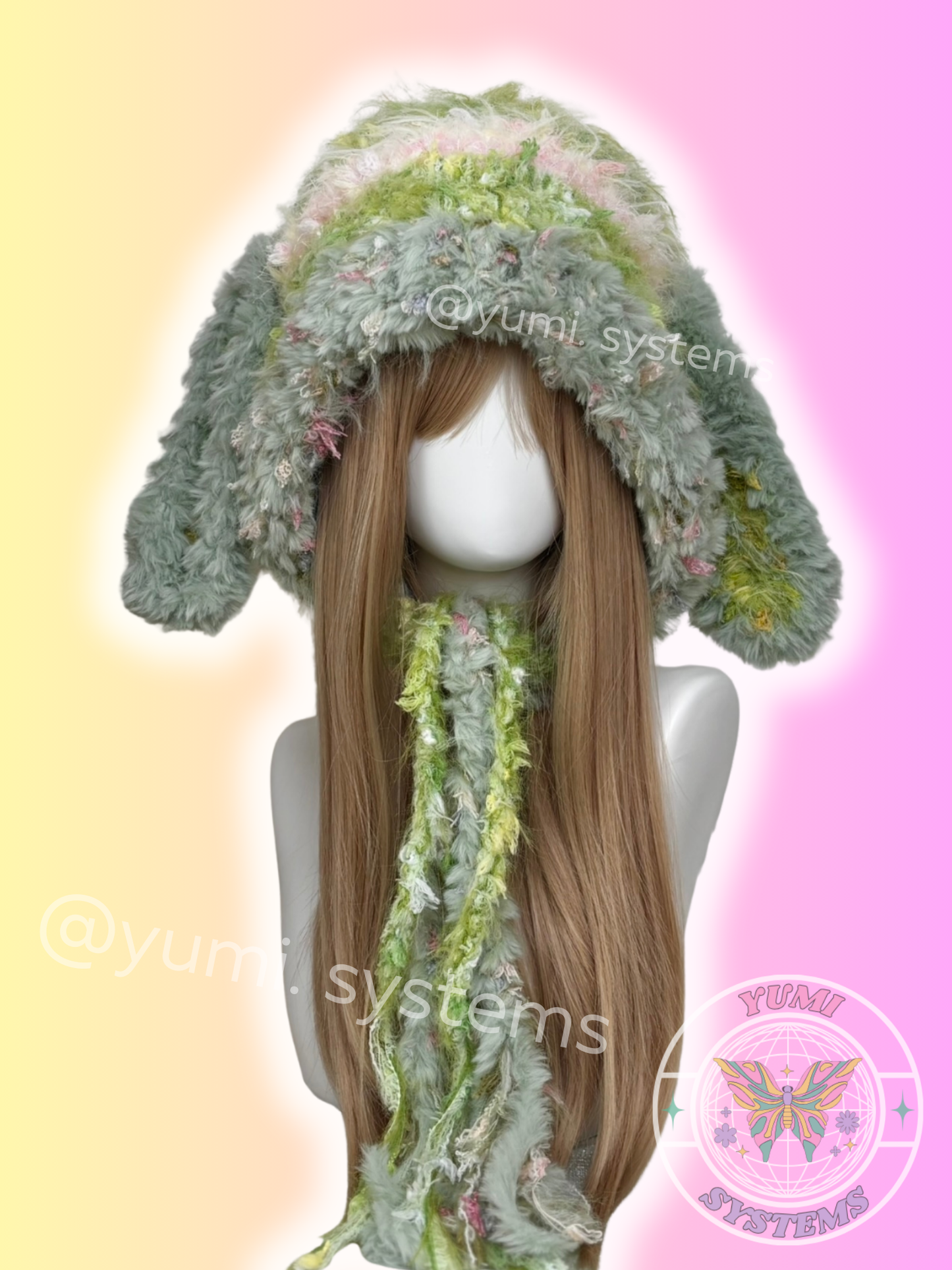 Close-up of a thick, colorful handmade rabbit ear hood with long tassels and fuzzy textures on a mannequin.