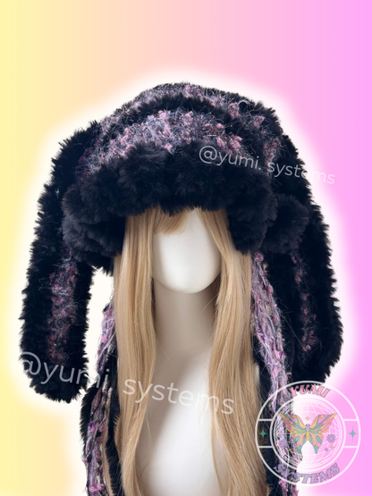 Oversized handmade black and purple fuzzy beanie with long rabbit-like ears and braids on a mannequin.