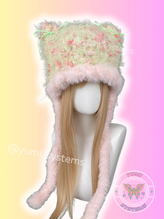 A collection of YUMI SYSTEMS handmade thick plush crochet hats in various colors including moss green, leopard print, pastel lavender, and mint green.